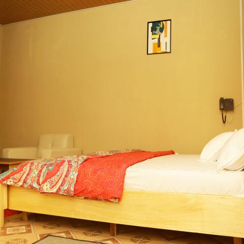 Standard room: bed with orange throw
